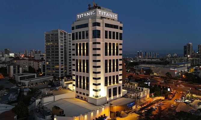 Titanic Business Kartal stands illuminated against the evening sky, surrounded by city lights and modern buildings