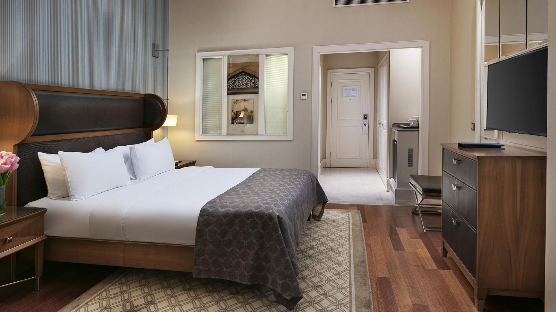 A Superior Room at Titanic Business Kartal in Istanbul with a bed, dresser, and TV.