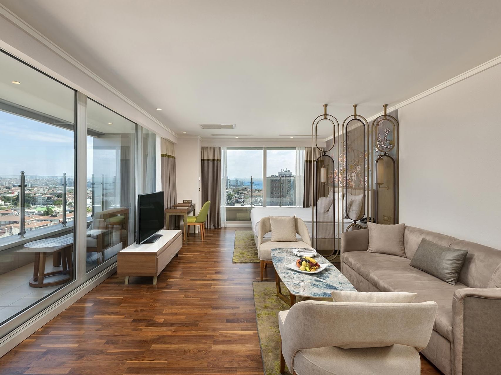 Junior Sea View Suite, living room with sofa, TV and city view at Titanic Port Bakirkoy