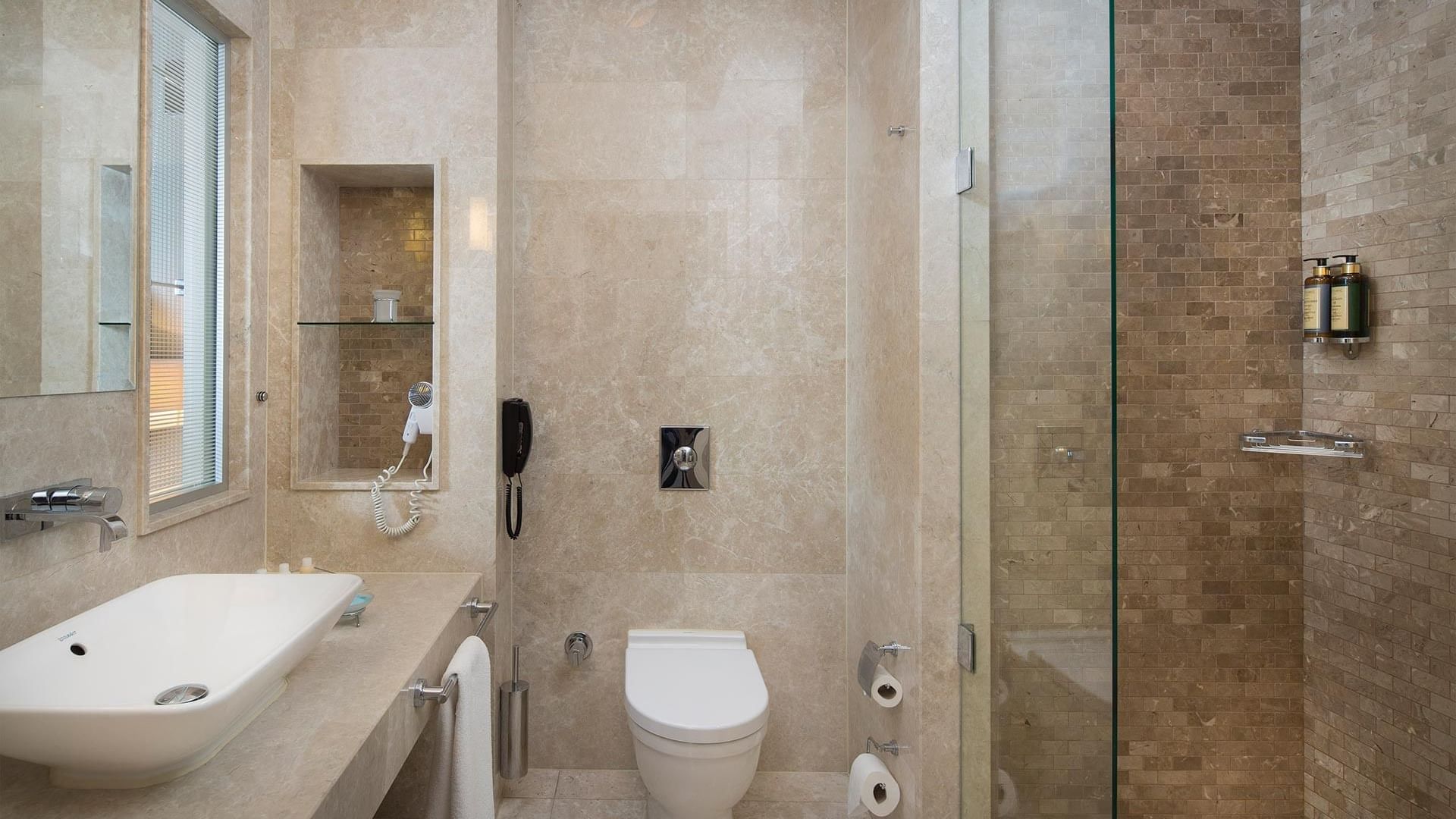 Modern bathroom with a sink, toilet, and shower at Titanic Business Kartal in Istanbul.