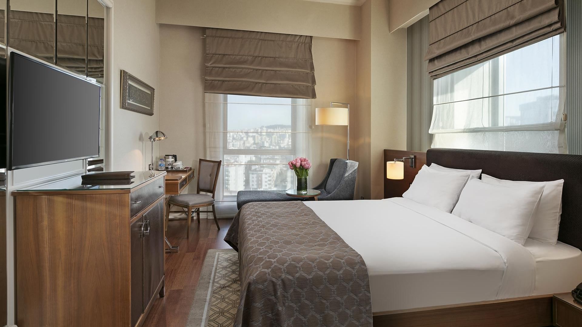Deluxe Room with a queen bed, desk, and cityscape view at Titanic Business Kartal in Istanbul.