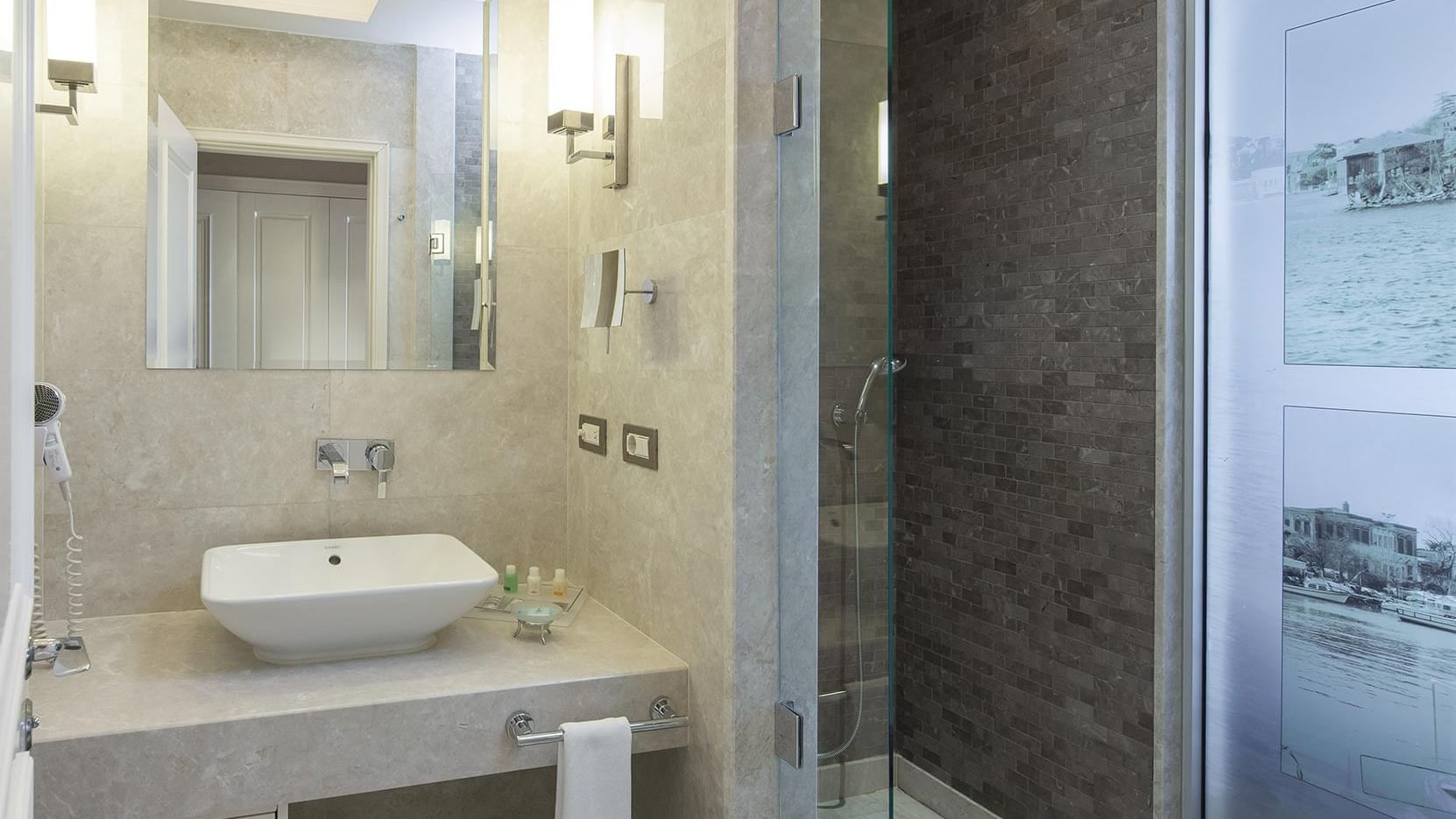 Modern bathroom with a large sink and glass shower at Titanic Business Kartal in Istanbul.