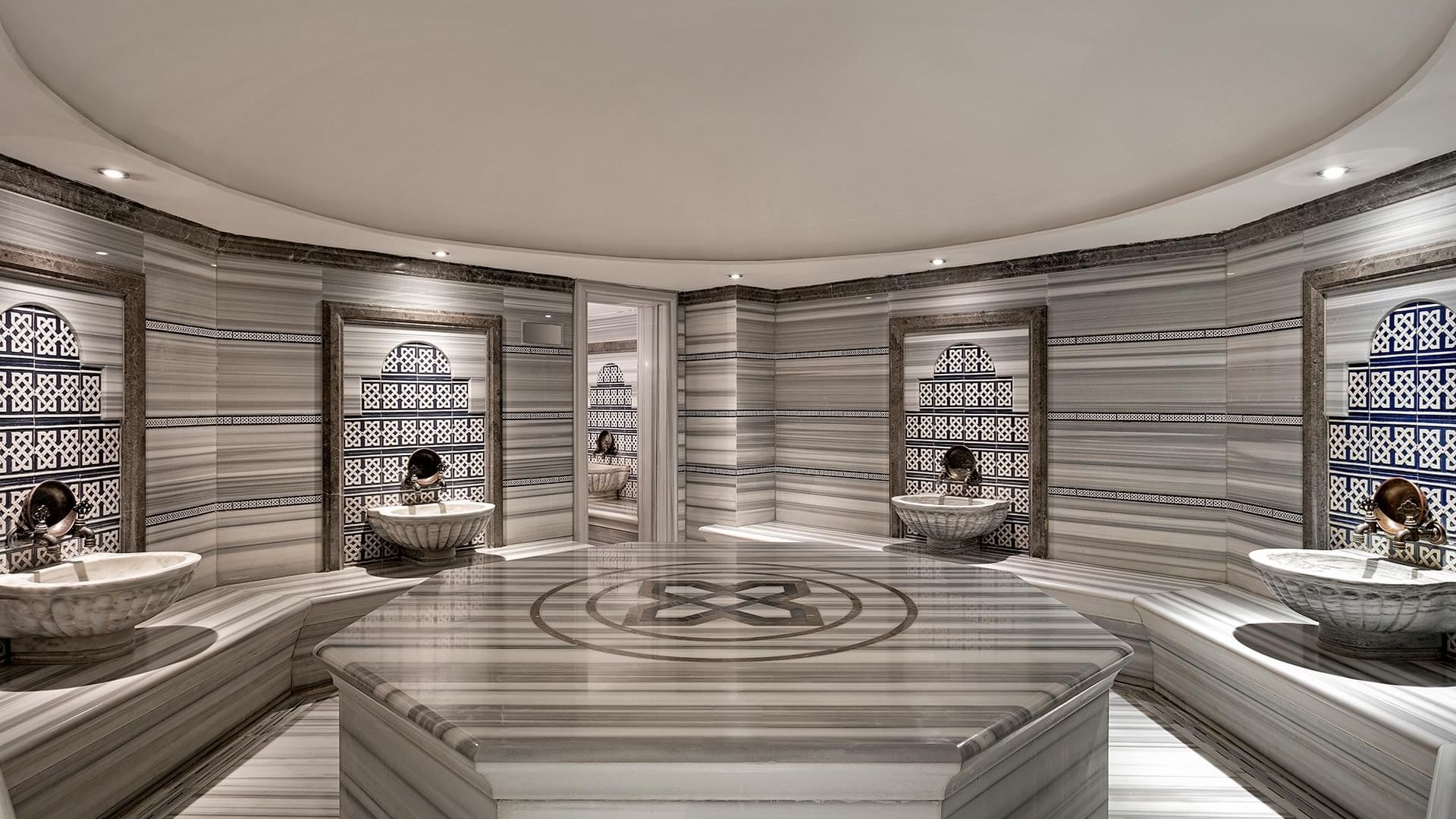 A luxurious spa with stone floors and elegant sinks at Titanic Business Kartal in Istanbul.