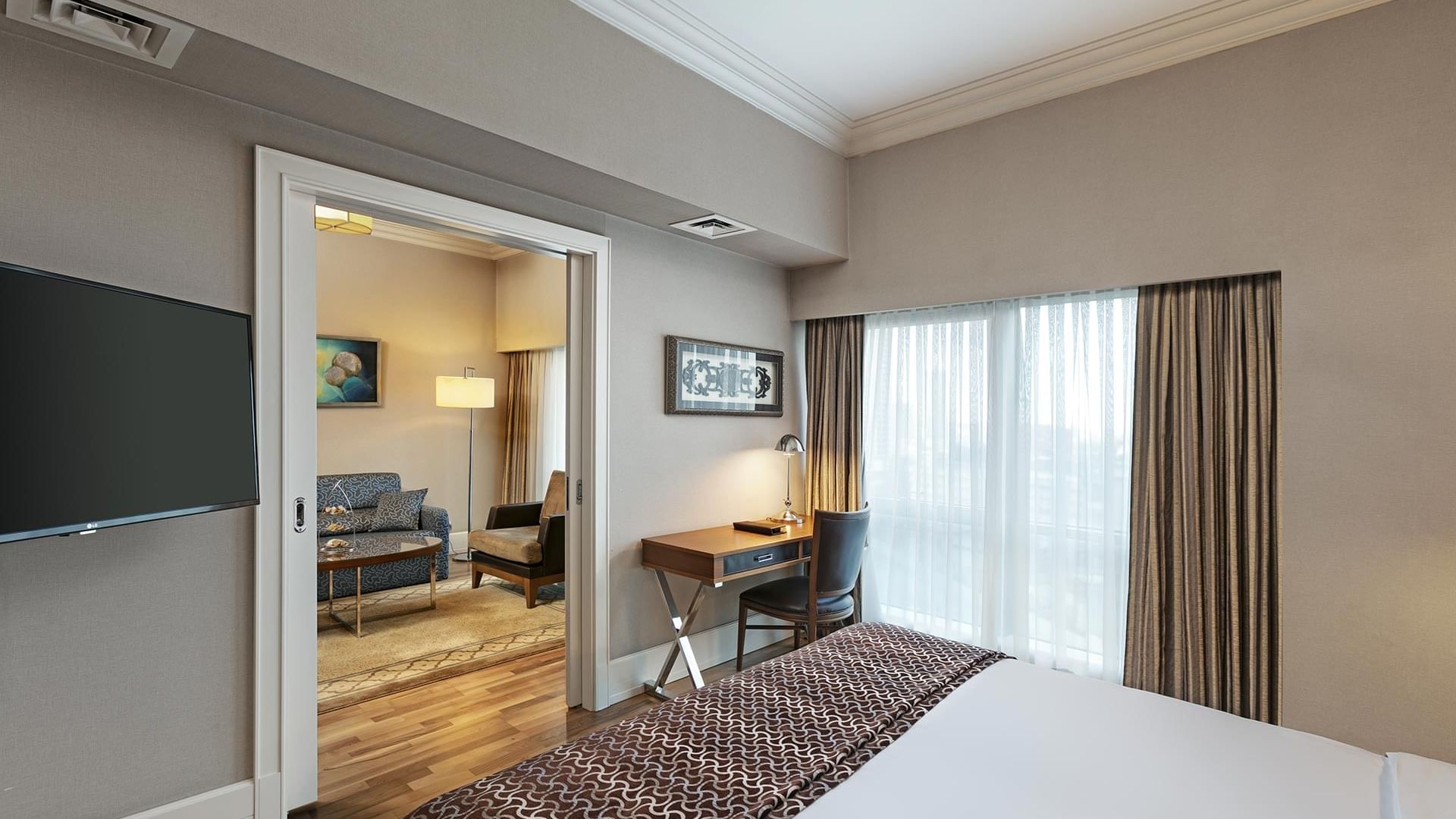 A bedroom with a large bed, a desk, and a living area at Titanic Business Kartal in Istanbul.