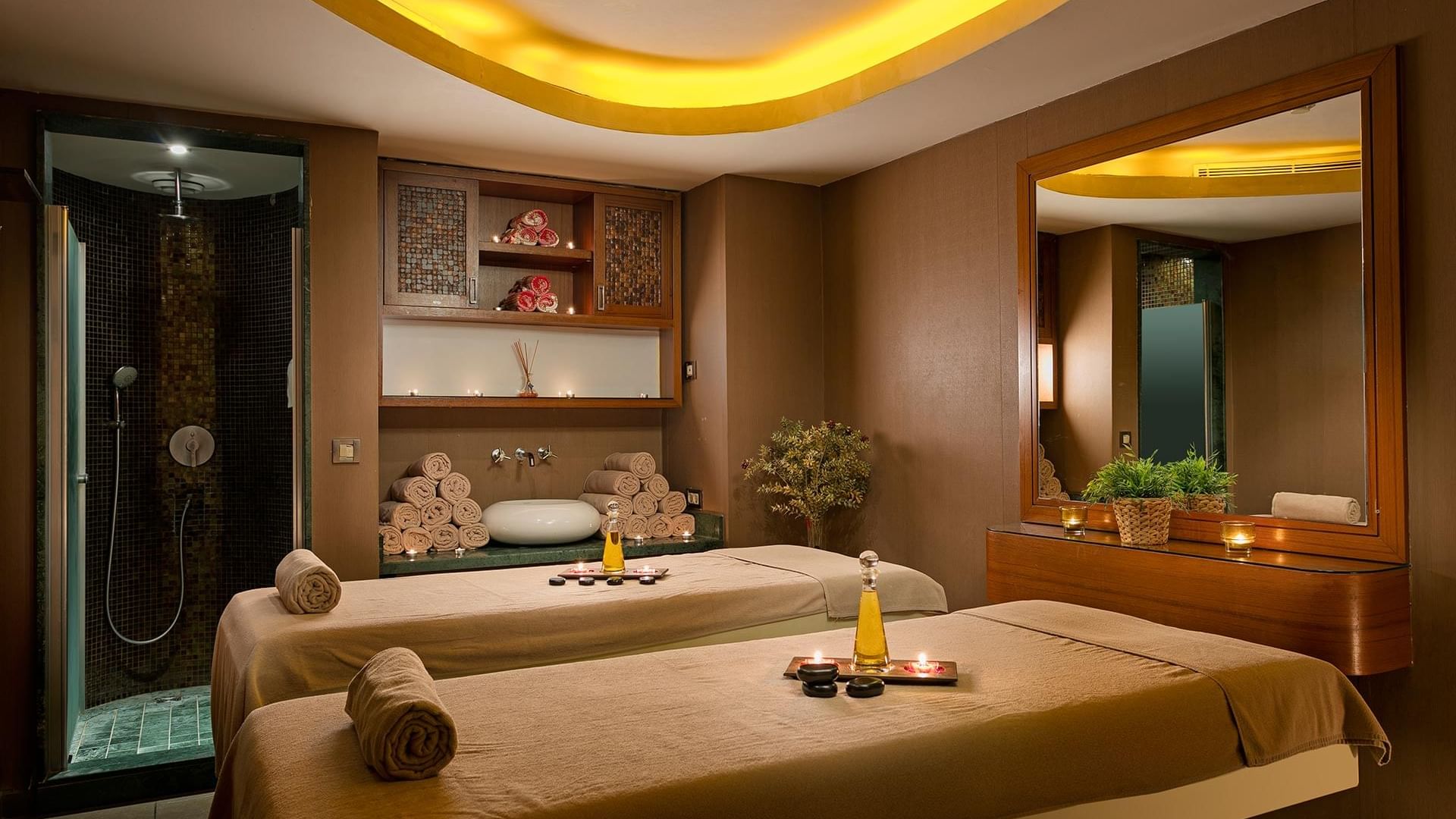 Two massage tables with towels and oils in a spa room at Titanic Business Kartal in Istanbul.