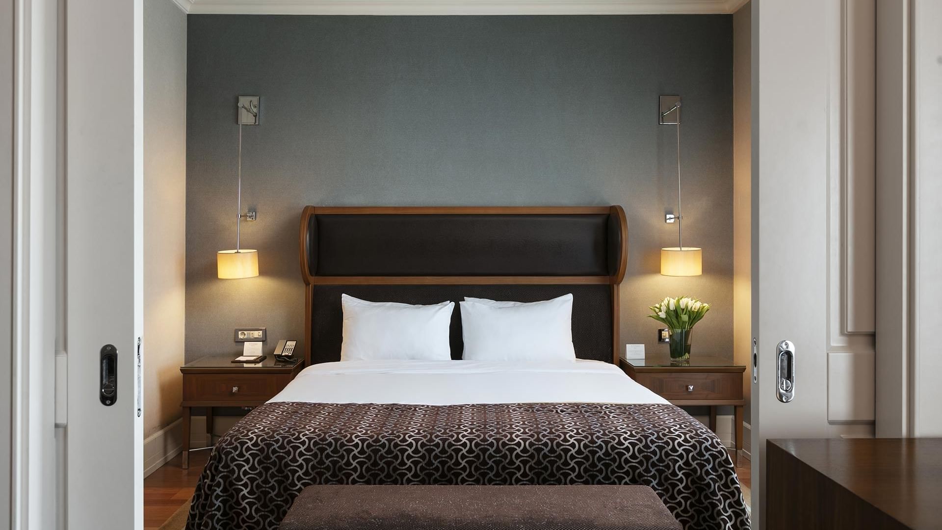 Elegant Club Suite bedroom at Titanic Business Kartal in Istanbul with a king-sized bed and floral decor.