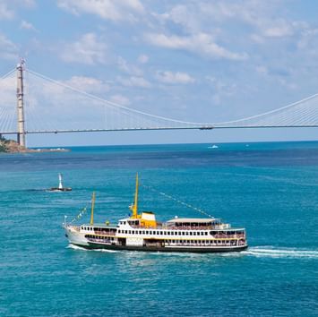 Distant view of a boat sailing in the sea in Ferries and Bosphorus Tour near Titanic Business Kartal