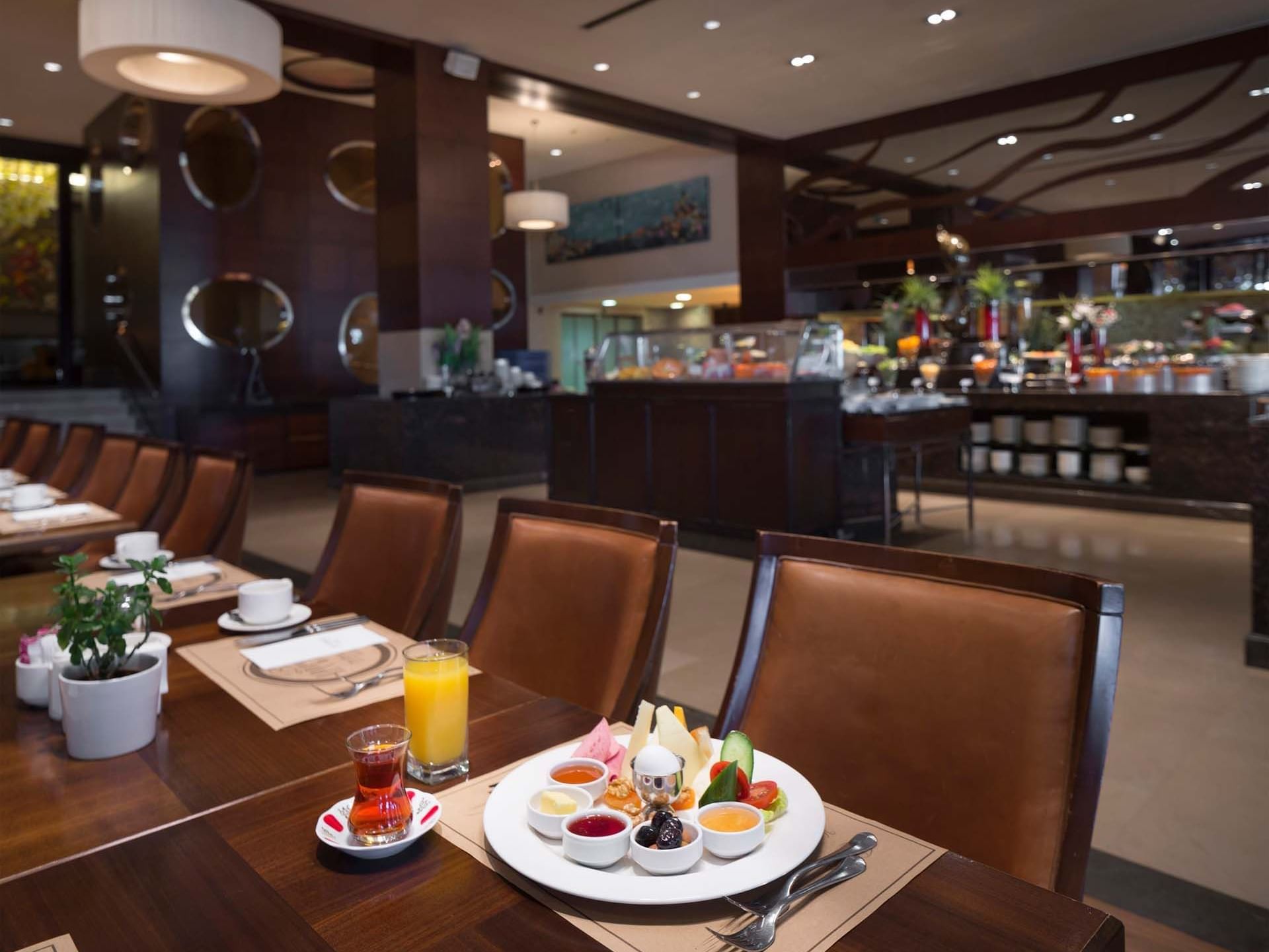 Plate of fruit and beverages on a table in a restaurant at Titanic Business Kartal.