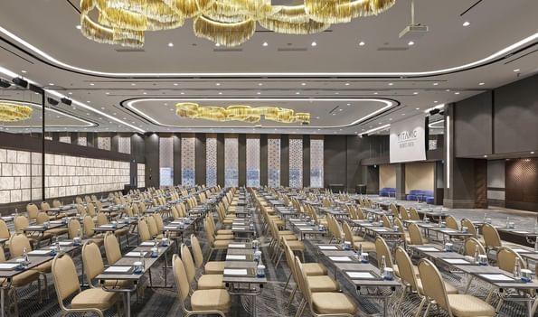Large event room with rows of tables and chairs, ornate chandeliers, at Titanic Business Kartal in Istanbul.