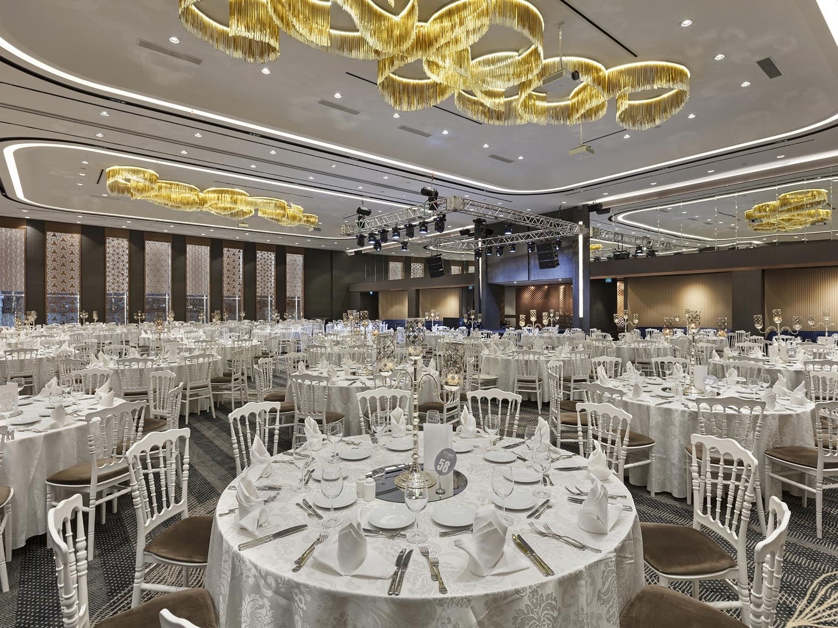 Banquet hall with round tables and chairs set for an event at Titanic Business Kartal.