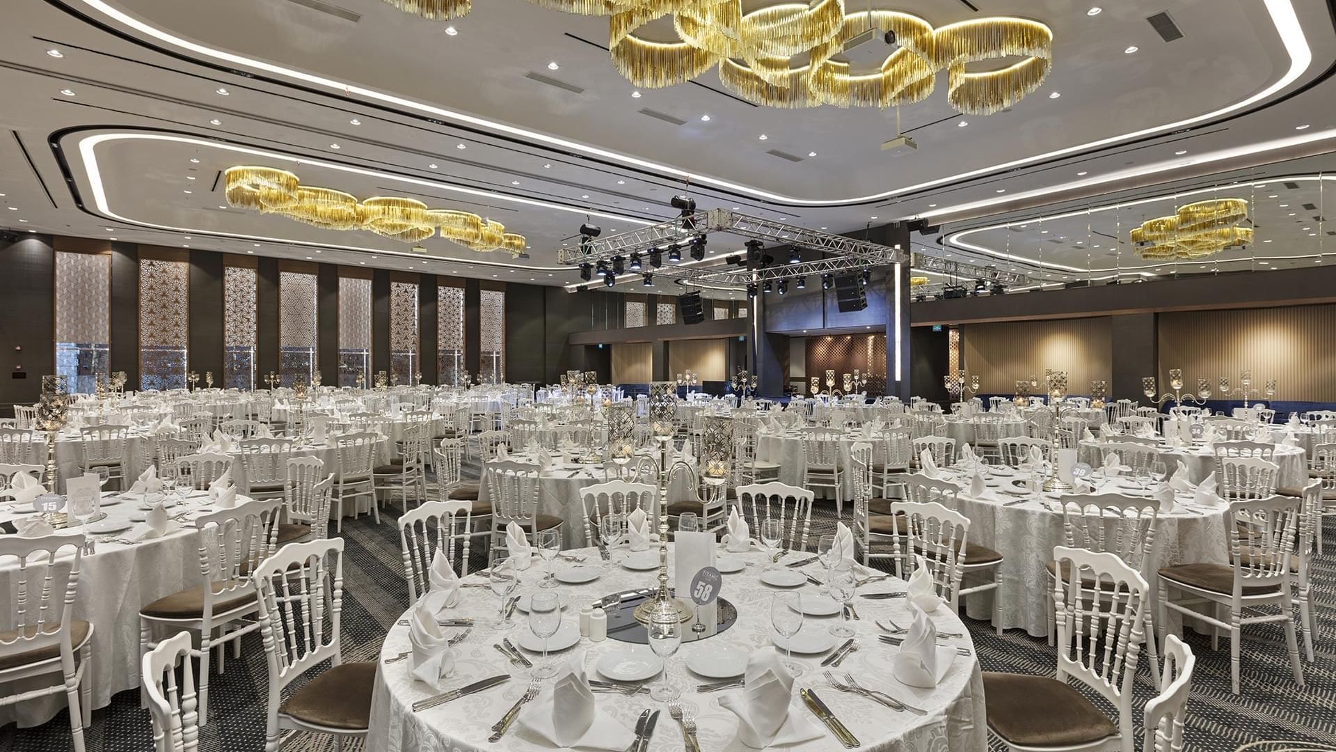 Large hall with set banquet tables and chairs for weddings at Titanic Business Kartal in Istanbul.