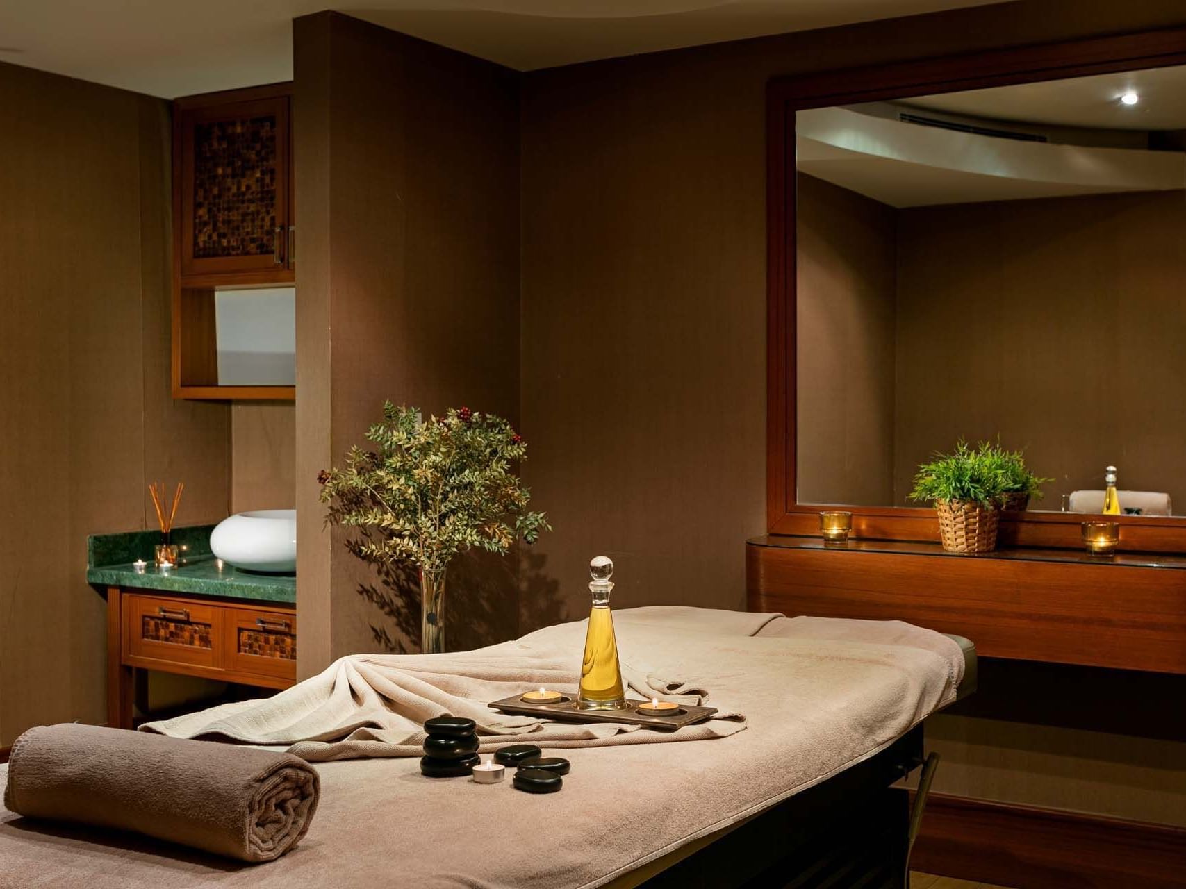 Spa room with massage table, candles, and towel at Titanic Business Kartal.
