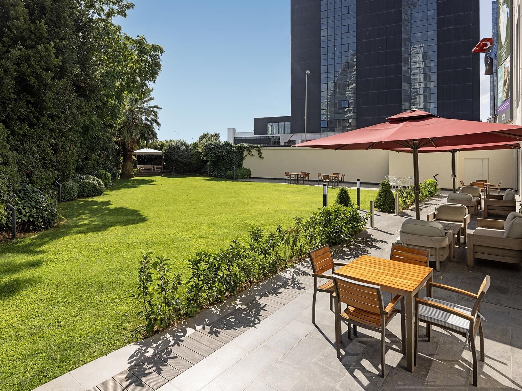 Cozy loungers and tables arranged outdoors on a sunny day at Titanic Business Kartal