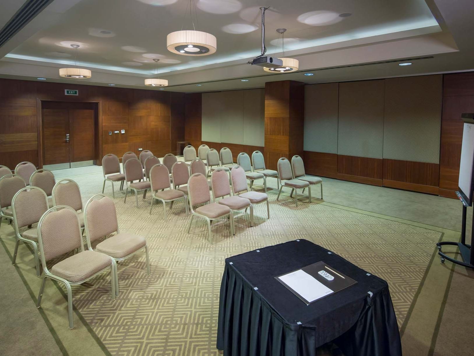 Modern meeting room with chairs, carpet, and projector at Titanic Business Kartal.